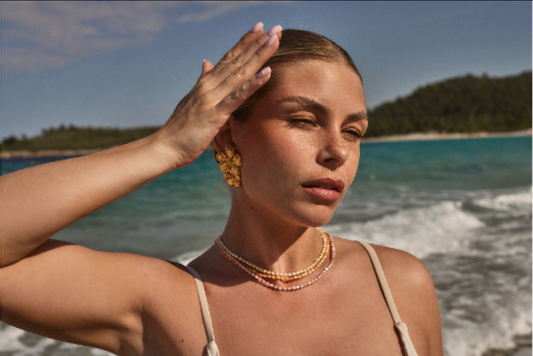 Bikini model on the beach in Greece with big flower statement earrings